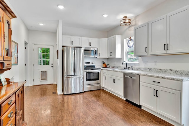 2639 Distillery Rd, Greenbrier, TN 37073 - kitchen featuring stainless steel appliances, a sink, wood finished floors, white cabinetry, and recessed lighting