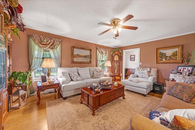 2890 Nance Bend Rd, Clifton, TN 38425 - living area with a textured ceiling, ceiling fan, light wood-style floors, ornamental molding, and wooden walls