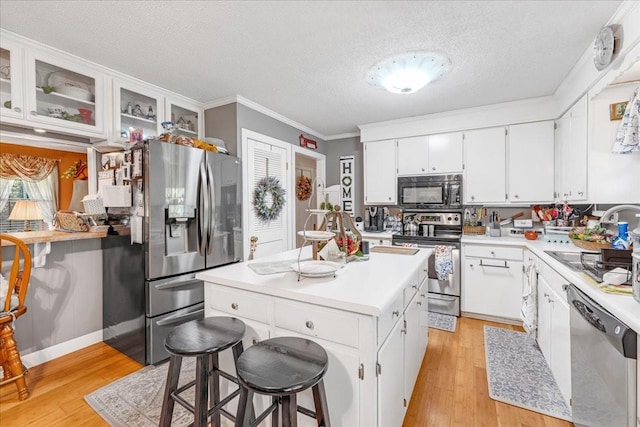 2890 Nance Bend Rd, Clifton, TN 38425 - kitchen featuring stainless steel appliances, a textured ceiling, a kitchen island, light wood-type flooring, and a sink