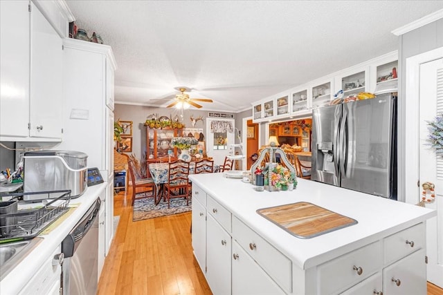 2890 Nance Bend Rd, Clifton, TN 38425 - kitchen with stainless steel appliances, a center island, ornamental molding, light countertops, and white cabinetry