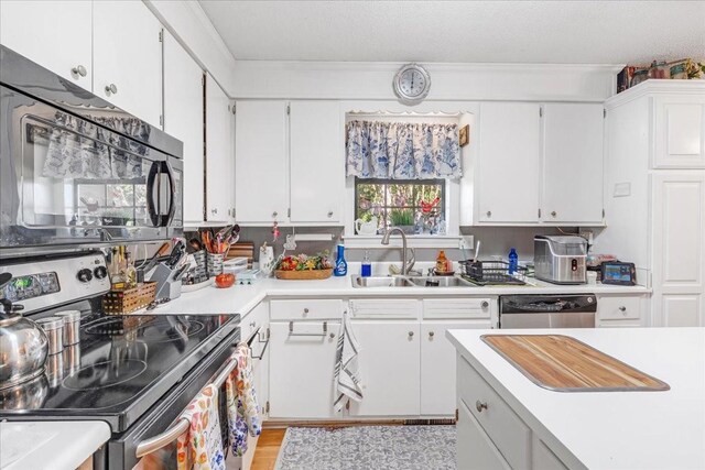 2890 Nance Bend Rd, Clifton, TN 38425 - kitchen with stainless steel appliances, a sink, light countertops, white cabinets, and light wood-type flooring
