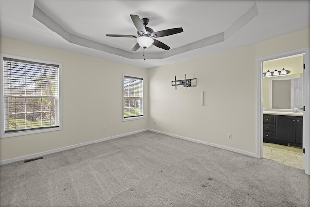 5009 Lanier Dr, Greenbrier, TN 37073 - unfurnished bedroom with a tray ceiling, light colored carpet, baseboards, ensuite bath, and a ceiling fan