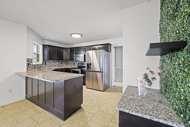 5009 Lanier Dr, Greenbrier, TN 37073 - kitchen with stainless steel appliances, a peninsula, light stone counters, backsplash, and light tile patterned floors