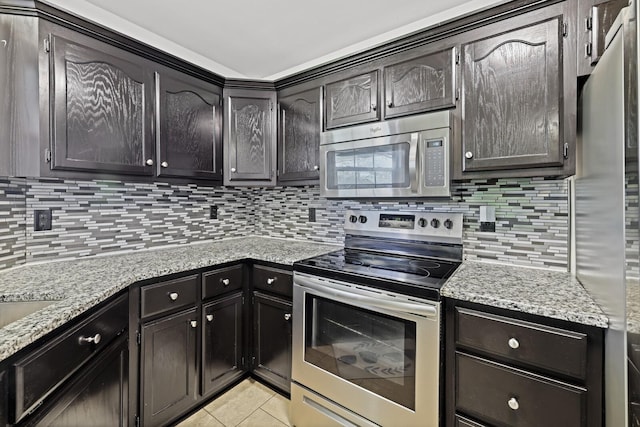 5009 Lanier Dr, Greenbrier, TN 37073 - kitchen featuring appliances with stainless steel finishes, decorative backsplash, light tile patterned floors, and light stone countertops