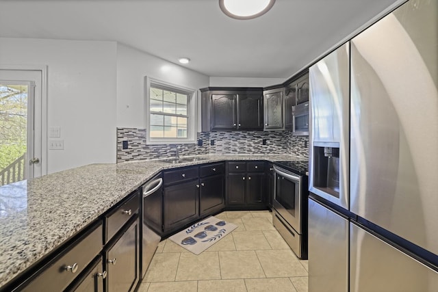 5009 Lanier Dr, Greenbrier, TN 37073 - kitchen featuring stainless steel appliances, decorative backsplash, light stone counters, and light tile patterned floors