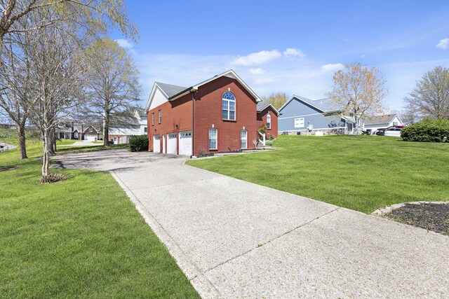 5009 Lanier Dr, Greenbrier, TN 37073 - view of home's exterior with an attached garage, concrete driveway, brick siding, and a lawn