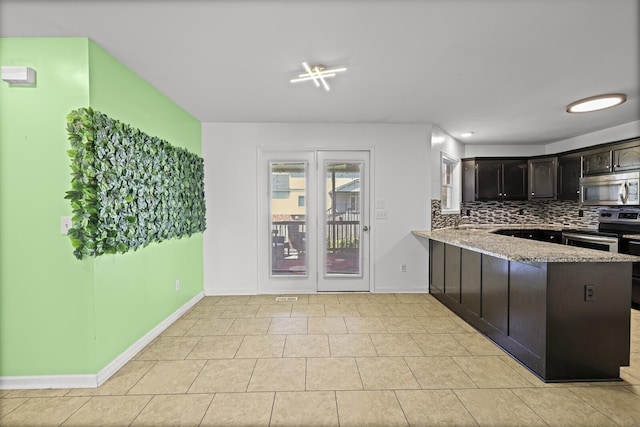 5009 Lanier Dr, Greenbrier, TN 37073 - kitchen with stainless steel appliances, decorative backsplash, a peninsula, light stone countertops, and baseboards