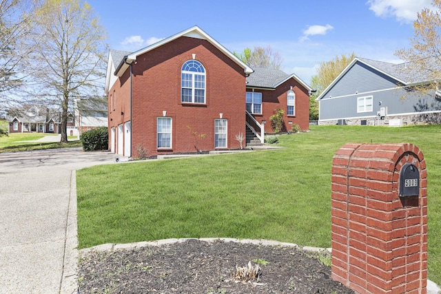 5009 Lanier Dr, Greenbrier, TN 37073 - view of home's exterior featuring asphalt driveway, brick siding, a yard, and an attached garage