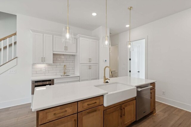 206G N 9th St, Nashville, TN 37206 - kitchen featuring a sink, stainless steel dishwasher, light wood-style flooring, tasteful backsplash, and baseboards
