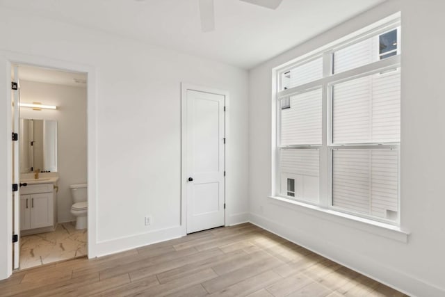 206G N 9th St, Nashville, TN 37206 - unfurnished bedroom featuring baseboards, light wood-style flooring, connected bathroom, and ceiling fan