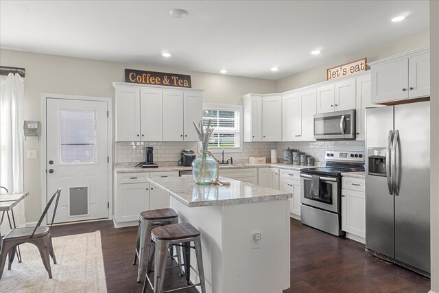 1020 Corey Dr, Lewisburg, TN 37091 - kitchen with appliances with stainless steel finishes, a center island, dark wood-style floors, white cabinetry, and recessed lighting