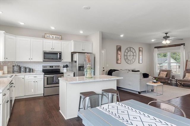 1020 Corey Dr, Lewisburg, TN 37091 - kitchen featuring stainless steel appliances, open floor plan, tasteful backsplash, dark wood finished floors, and a center island
