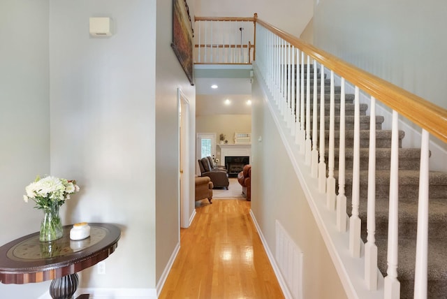 1513 Bunbury Dr, Thompsons Station, TN 37179 - staircase with wood finished floors, a high ceiling, a fireplace, and baseboards