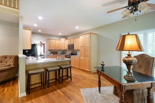 1513 Bunbury Dr, Thompsons Station, TN 37179 - kitchen with black microwave, light brown cabinetry, light wood finished floors, electric range oven, and a peninsula