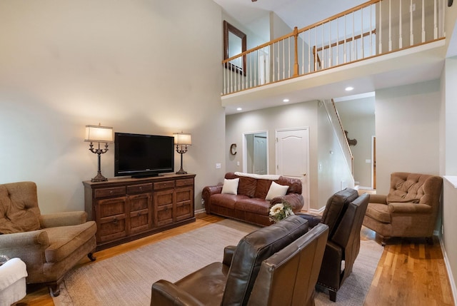 1513 Bunbury Dr, Thompsons Station, TN 37179 - living room featuring light wood-style floors, stairs, a towering ceiling, and baseboards