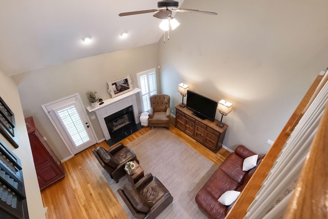 1513 Bunbury Dr, Thompsons Station, TN 37179 - living area with light wood finished floors, a fireplace, a ceiling fan, high vaulted ceiling, and stairs