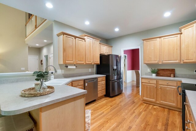 1513 Bunbury Dr, Thompsons Station, TN 37179 - kitchen featuring appliances with stainless steel finishes, light brown cabinetry, light wood-style floors, a sink, and recessed lighting
