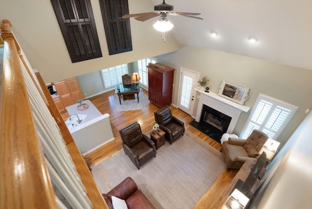 1513 Bunbury Dr, Thompsons Station, TN 37179 - living area with a premium fireplace, wood finished floors, healthy amount of natural light, high vaulted ceiling, and ceiling fan