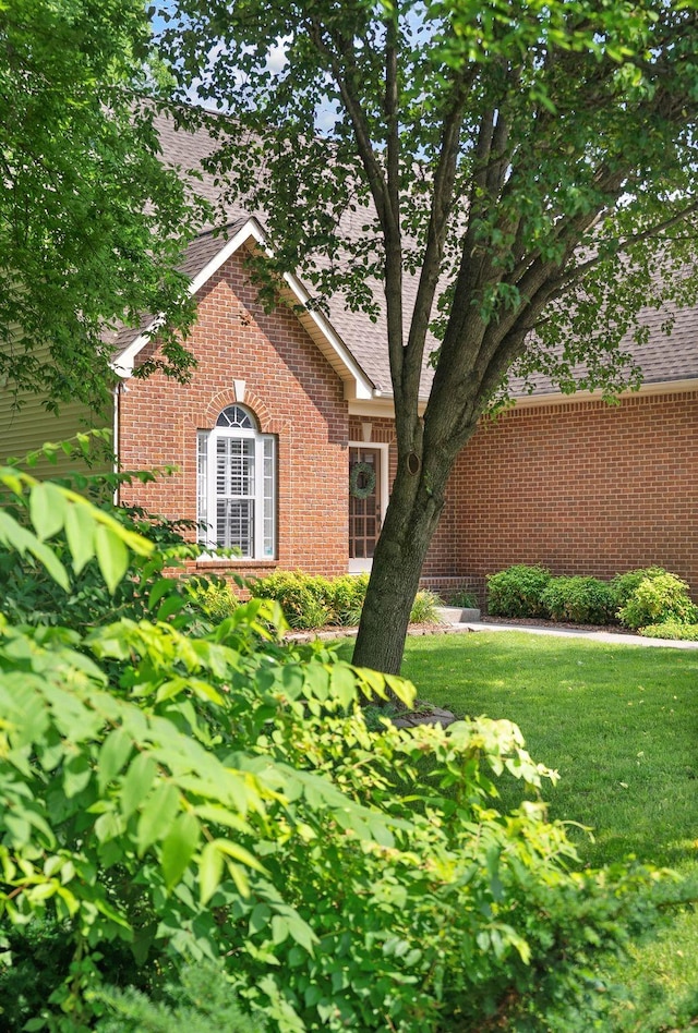 1513 Bunbury Dr, Thompsons Station, TN 37179 - view of front facade featuring brick siding, roof with shingles, and a front yard