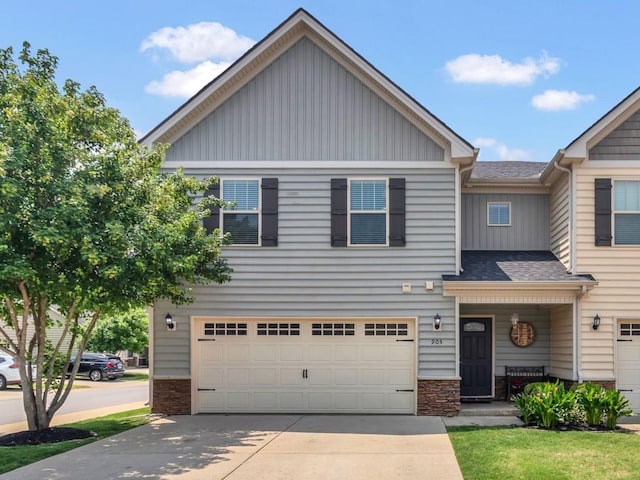 905 Azeri Ave, Murfreesboro, TN 37128 - view of front of house with board and batten siding, an attached garage, stone siding, driveway, and roof with shingles