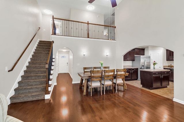 905 Azeri Ave, Murfreesboro, TN 37128 - dining space featuring ceiling fan, arched walkways, dark wood-style floors, a high ceiling, and baseboards
