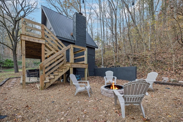 8861 Aunt Helen Rd, Silver Point, TN 38582 - rear view of house with stairway, an outdoor fire pit, metal roof, a chimney, and a wooden deck