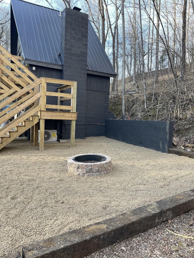 8861 Aunt Helen Rd, Silver Point, TN 38582 - view of side of home featuring a fire pit, metal roof, stairs, a chimney, and ac unit