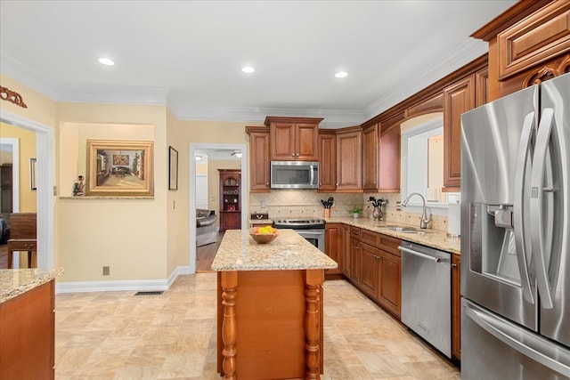 1446 Kittrell Rd, Franklin, TN 37064 - kitchen with appliances with stainless steel finishes, light stone counters, a kitchen island, backsplash, and ornamental molding