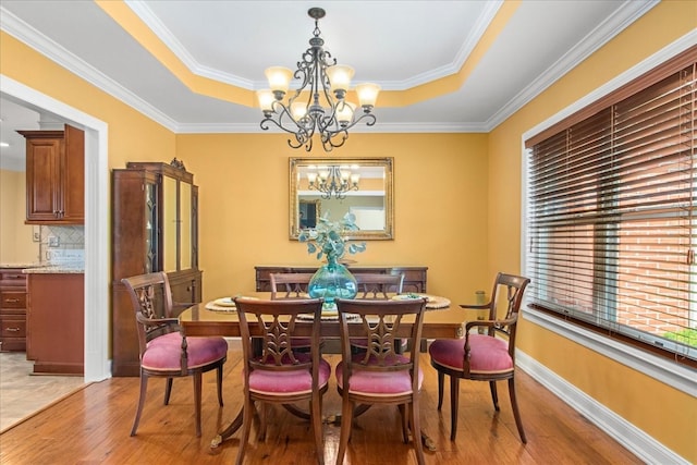 1446 Kittrell Rd, Franklin, TN 37064 - dining room with a raised ceiling, a chandelier, light wood-style flooring, and crown molding