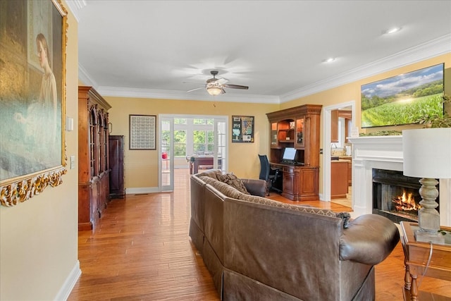 1446 Kittrell Rd, Franklin, TN 37064 - living room featuring a warm lit fireplace, ornamental molding, a ceiling fan, light wood-style floors, and an office area
