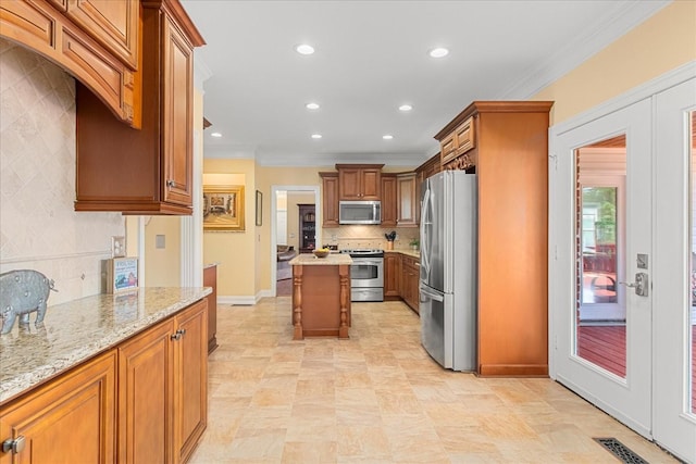 1446 Kittrell Rd, Franklin, TN 37064 - kitchen featuring stainless steel appliances, ornamental molding, brown cabinets, light stone countertops, and tasteful backsplash