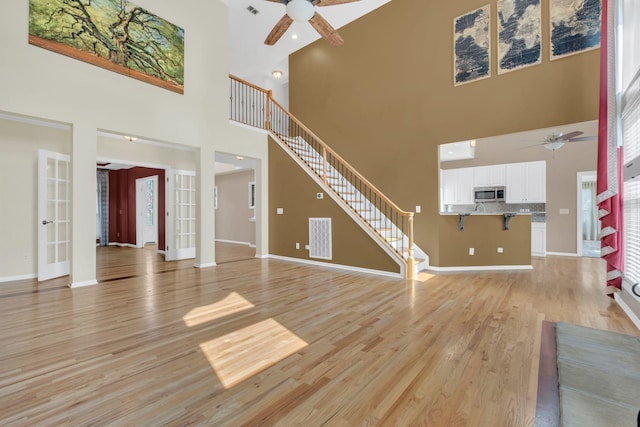 2005 Dunedin Cv, Old Hickory, TN 37138 - unfurnished living room with a ceiling fan, a towering ceiling, light wood finished floors, and stairs