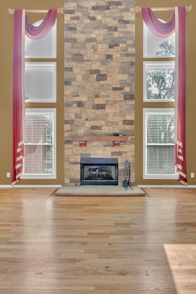 2005 Dunedin Cv, Old Hickory, TN 37138 - unfurnished living room with wood finished floors, a stone fireplace, plenty of natural light, and baseboards
