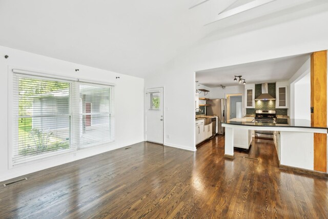 1306 Maymont Dr, Murfreesboro, TN 37130 - kitchen featuring wall chimney range hood, appliances with stainless steel finishes, lofted ceiling, dark countertops, and tasteful backsplash