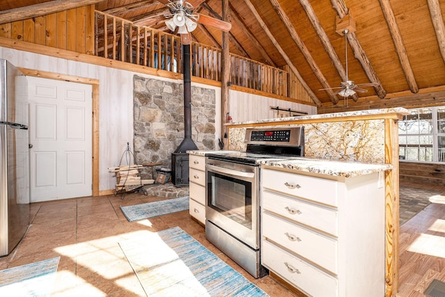 6720 Parker Rd, Lyles, TN 37098 - kitchen with stainless steel appliances, a ceiling fan, wooden ceiling, wood walls, and a wood stove