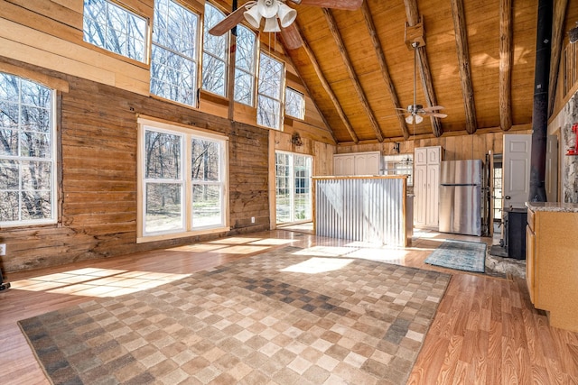 6720 Parker Rd, Lyles, TN 37098 - unfurnished living room featuring a ceiling fan, high vaulted ceiling, wooden ceiling with exposed beams, light wood-type flooring, and wooden walls