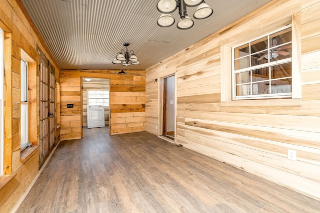 6720 Parker Rd, Lyles, TN 37098 - empty room with a chandelier, washer / dryer, wood walls, and wood finished floors