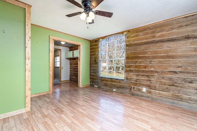 6720 Parker Rd, Lyles, TN 37098 - spare room with wood walls, a ceiling fan, light wood finished floors, baseboards, and crown molding