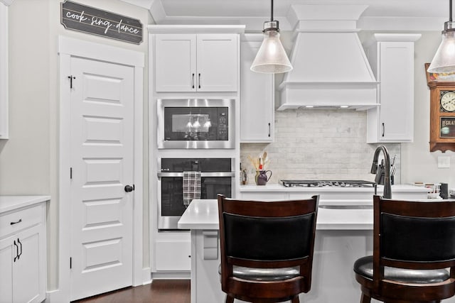 3814 Inlet Loop, Chattanooga, TN 37416 - kitchen featuring appliances with stainless steel finishes, custom exhaust hood, tasteful backsplash, a breakfast bar area, and light countertops