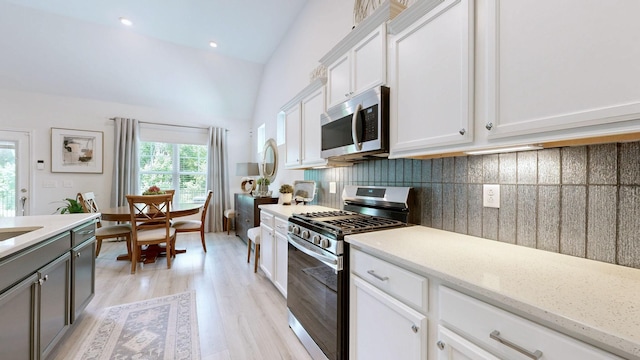 3632 Stormy Ln, Rockvale, TN 37153 - kitchen featuring appliances with stainless steel finishes, backsplash, light wood finished floors, white cabinets, and vaulted ceiling