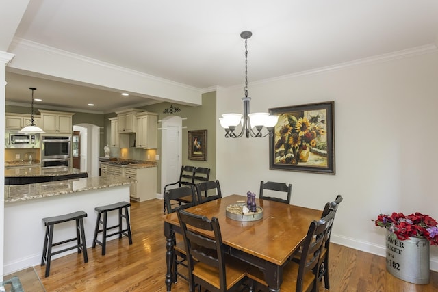 1414 Bernard Way, Franklin, TN 37067 - dining room featuring arched walkways, a chandelier, light wood-type flooring, ornamental molding, and baseboards