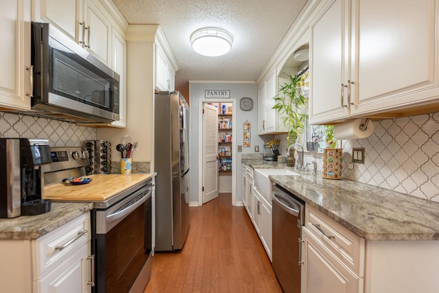 711 Hurricane Hill Dr, Waynesboro, TN 38485 - kitchen featuring stainless steel appliances, a sink, decorative backsplash, light wood-style flooring, and a textured ceiling