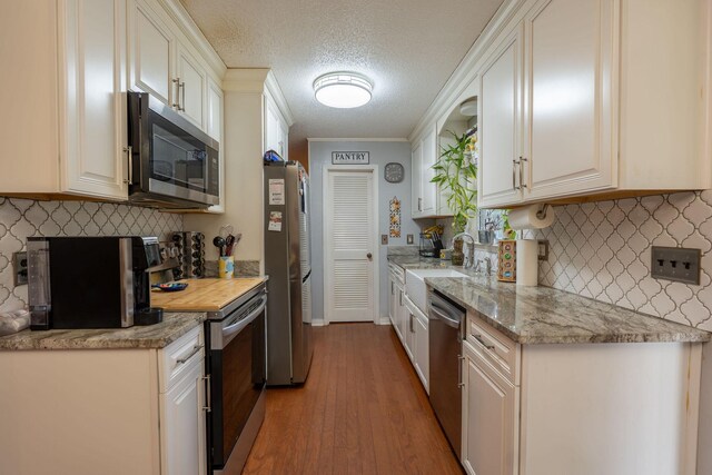 711 Hurricane Hill Dr, Waynesboro, TN 38485 - kitchen featuring stainless steel appliances, a sink, wood finished floors, decorative backsplash, and a textured ceiling
