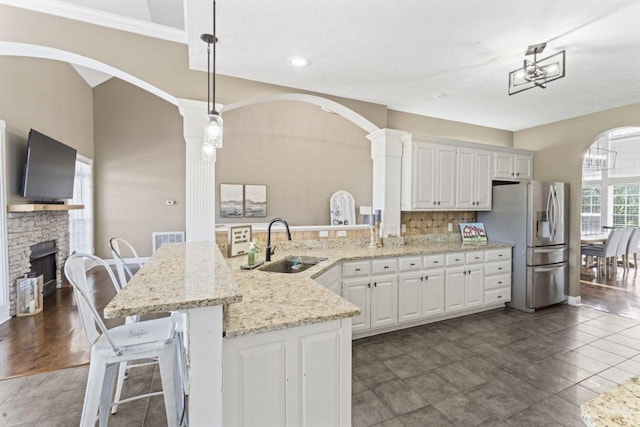 842 Shun Pike, Cottontown, TN 37048 - kitchen with stainless steel refrigerator with ice dispenser, a sink, a peninsula, decorative columns, and light stone countertops