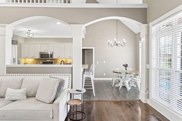 842 Shun Pike, Cottontown, TN 37048 - living area featuring ornate columns, a chandelier, arched walkways, dark wood-style floors, and baseboards