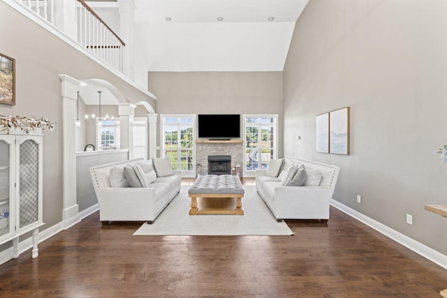 842 Shun Pike, Cottontown, TN 37048 - living room featuring ornate columns, a high ceiling, a stone fireplace, dark wood-type flooring, and baseboards