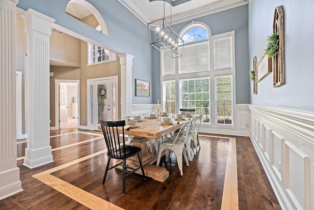 842 Shun Pike, Cottontown, TN 37048 - dining area featuring ornate columns, a decorative wall, dark wood-style floors, a wainscoted wall, and a towering ceiling