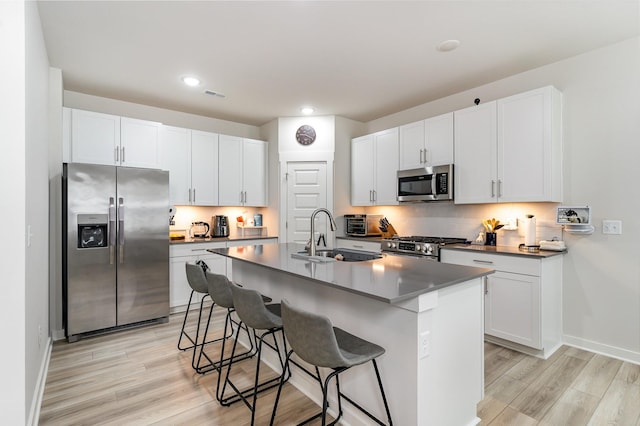 120 Ravens Crest Ave, Mount Juliet, TN 37122 - kitchen featuring stainless steel appliances, a breakfast bar, light wood finished floors, a sink, and white cabinets
