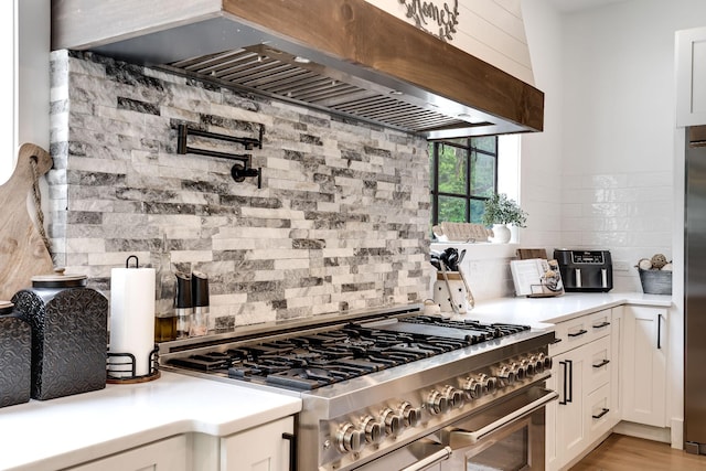 407 Hogans Branch Rd, Goodlettsville, TN 37072 - kitchen featuring stainless steel gas stove, custom range hood, tasteful backsplash, and white cabinets