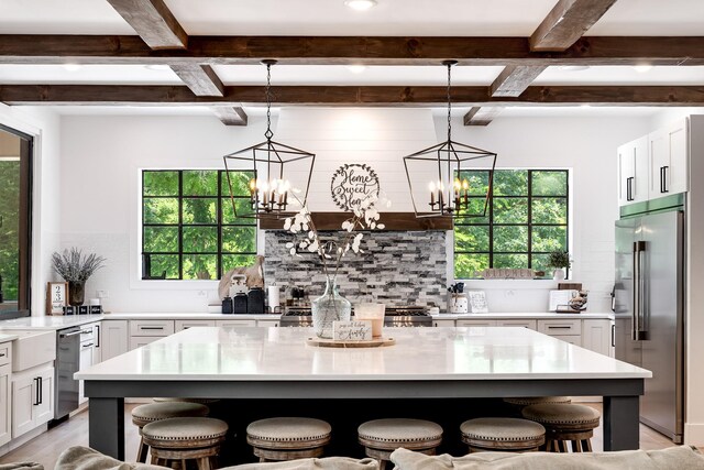 407 Hogans Branch Rd, Goodlettsville, TN 37072 - kitchen featuring stainless steel appliances, backsplash, a kitchen breakfast bar, beamed ceiling, and white cabinetry